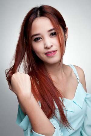 Portrait of beautiful young Asian woman on gray backgroundの写真素材