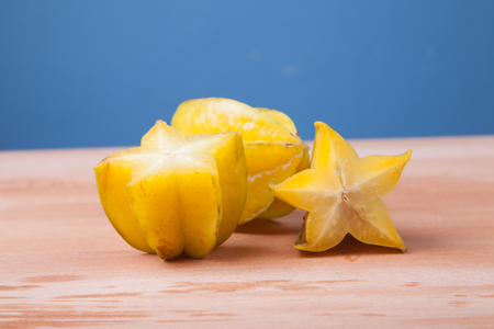 Half cut of starfruit on wooden table  and blue backgroundの写真素材