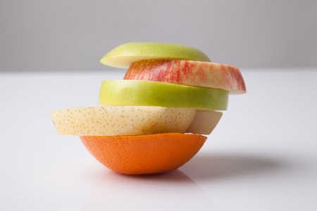 Stack of mix sliced fruits on white backgroundの写真素材