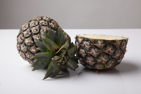 Half cut fresh pineapple on white backgroundの写真素材