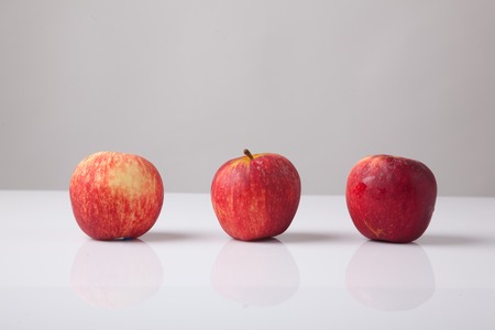 Three red apples  on white backgroundの写真素材