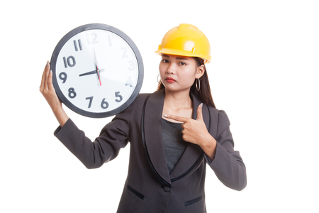 Asian engineer woman in bad mood with a clock  isolated on white background.の写真素材