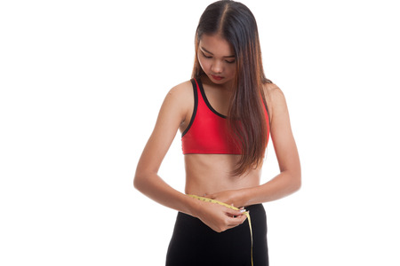Beautiful Asian healthy girl measuring her waist  isolated on white background.の写真素材