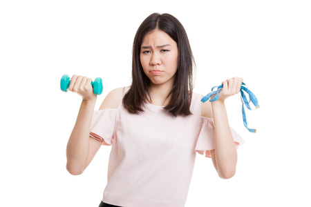 Exhausted  Asian woman with dumbbells and measuring tape  isolated on white background.の写真素材