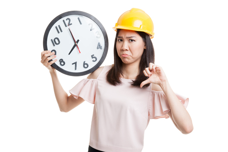 Asian engineer woman thumbs down with a clock  isolated on white background.の写真素材