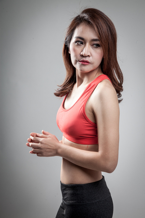 Asian strong healthy  girl  with muscular body on gray backgroundの写真素材