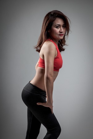 Asian strong healthy  girl  with muscular body on gray backgroundの写真素材