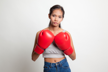 Young Asian woman with red boxing gloves on white backgroundの写真素材