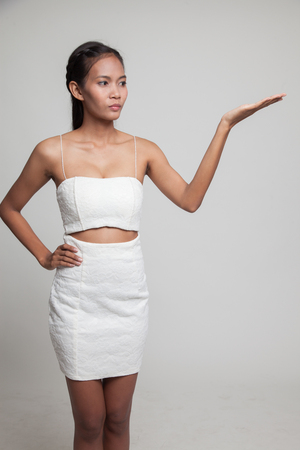Young Asian woman present with her hand  on gray backgroundの写真素材