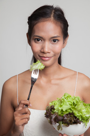 Healthy Asian woman with salad  on gray backgroundの写真素材