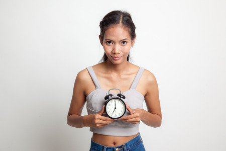 Young Asian woman smile with a clock on white backgroundの写真素材