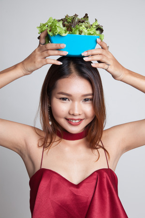 Healthy Asian woman with salad on gray backgroundの写真素材