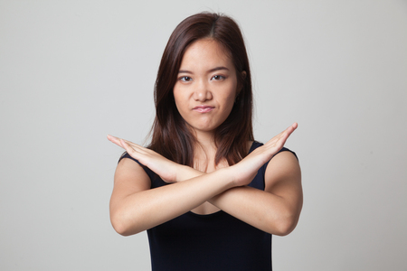 Beautiful young Asian woman say no on gray backgroundの写真素材