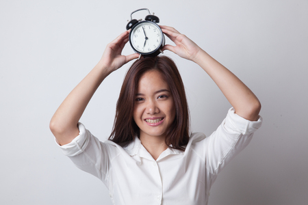Young Asian woman smile with a clock on white backgroundの写真素材