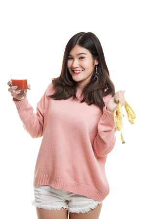 Young Asian woman with tomato juice and measuring tape isolated on white backgroundの写真素材