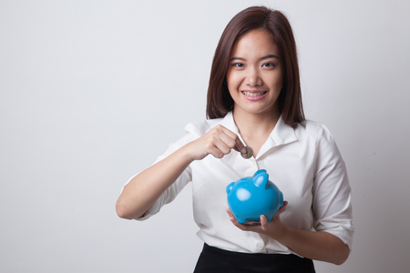 Asian woman with coin and pig coin bank on white backgroundの写真素材
