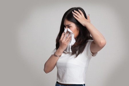 Young Asian woman got sick and flu on gray backgroundの写真素材