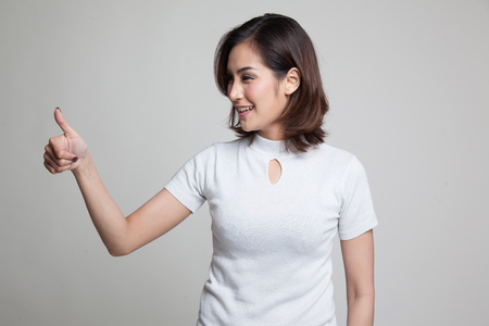 Asian woman thumbs up  and smile on gray backgroundの写真素材