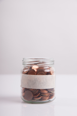 Money saving in the glass bottle for money concept on white backgroundの写真素材