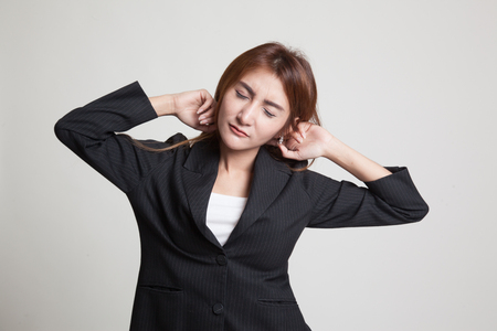 Sleepy young Asian woman yawn on gray backgroundの写真素材
