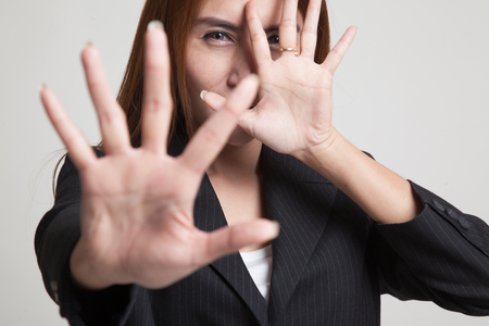 Young Asian woman hide her  face on gray backgroundの写真素材