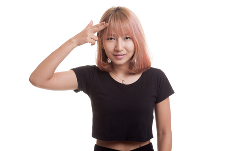 Beautiful young Asian woman holding fingers in gun gesture isolated on white backgroundの写真素材