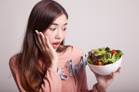 Healthy Asian woman with salad on gray backgroundの写真素材