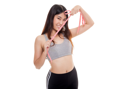 Beautiful Asian healthy girl with measuring tape isolated on white backgroundの写真素材