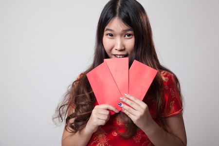 Asian girl in chinese cheongsam dress with red envelope on gray backgroundの写真素材
