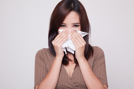 Young Asian woman got sick and flu on gray backgroundの写真素材