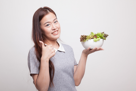 Healthy Asian woman thumbs up with salad on gray backgroundの写真素材