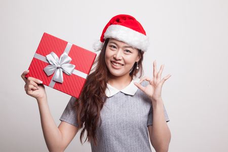 Young Asian woman show OK with a gift box on gray backgroundの写真素材