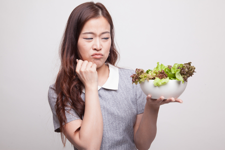 Asian woman hate salad on gray backgroundの写真素材