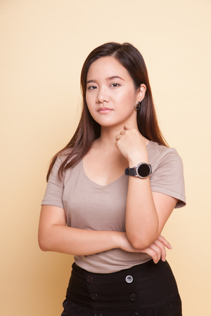 Beautiful young Asian woman on beige backgroundの写真素材