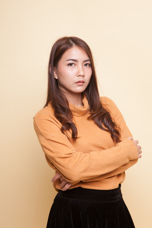 Beautiful young Asian woman on beige backgroundの写真素材