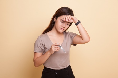 Young Asian woman got sick and flu on beige backgroundの写真素材