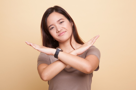 Beautiful young Asian woman say no on beige backgroundの写真素材