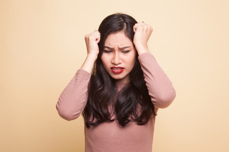 Young Asian woman got sick and  headache on beige backgroundの写真素材