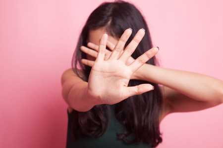 Young Asian woman hide her  face on pink backgroundの写真素材