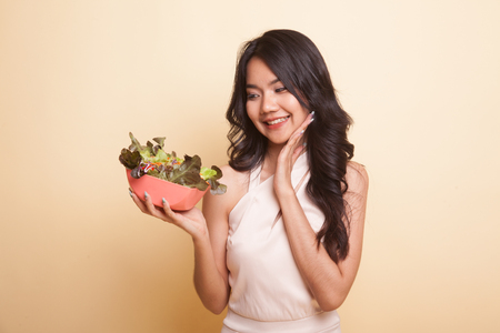 Healthy Asian woman with salad  on beige backgroundの写真素材