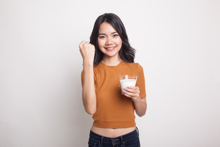Healthy Asian woman drinking a glass of milk on white backgroundの写真素材