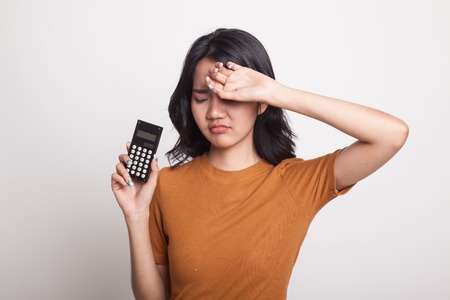 Asian woman got  headache with calculator on white backgroundの写真素材