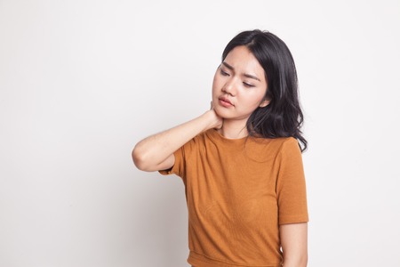 Young Asian woman got neck pain on white backgroundの写真素材