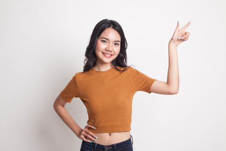 Young Asian woman smile and point on white backgroundの写真素材