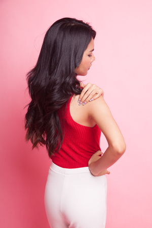 Young Asian woman got back pain on pink backgroundの写真素材