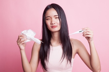 Young Asian woman got sick and flu on pink background