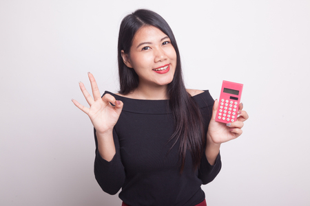 Asian woman show OK with calculator on white backgroundの写真素材
