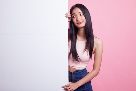 Young Asian woman with blank sign on pink backgroundの写真素材