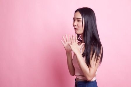 Young Asian woman is surprised and smile on pink background