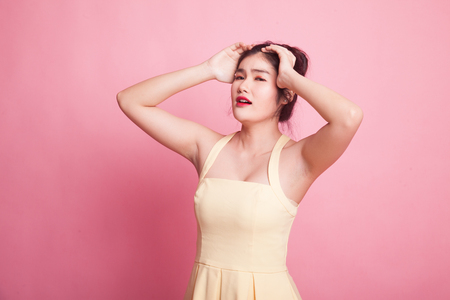 Stressed young Asian businesswoman scream out on pink backgroundの写真素材